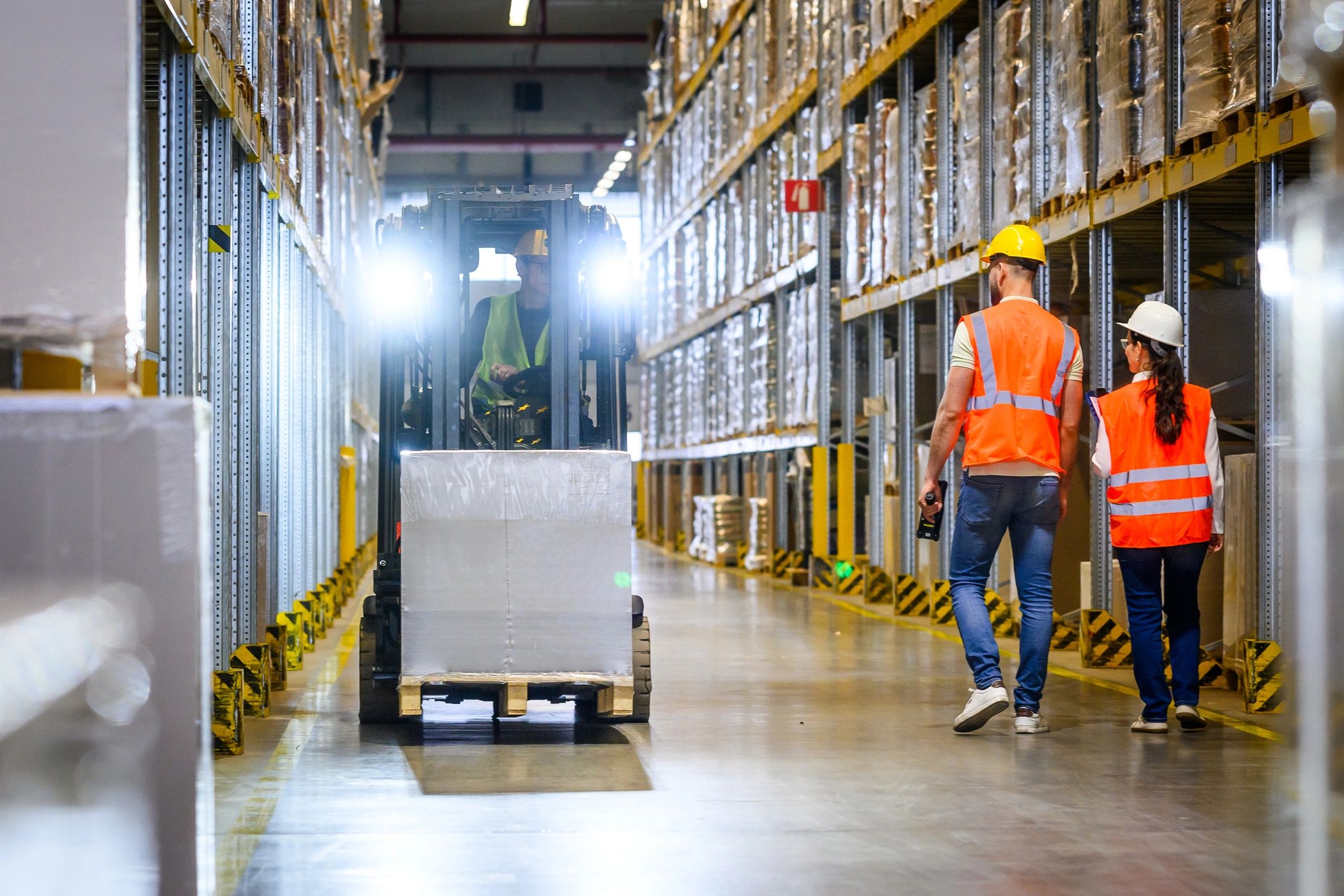 Warehouse fulfillment team coordinating pallet movement at a loading dock